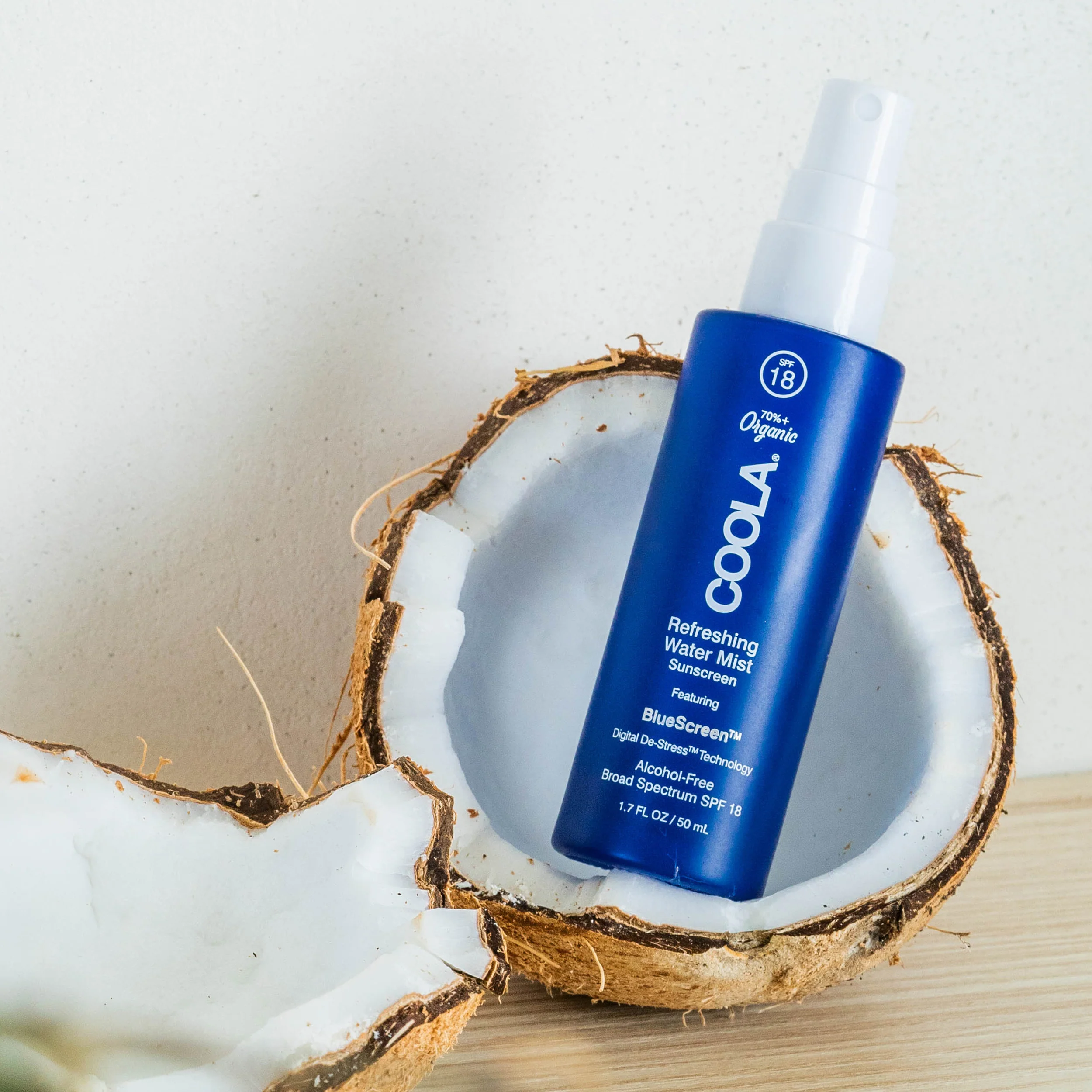 an image of the coola refreshing water mist bottle inside of half a coconut.