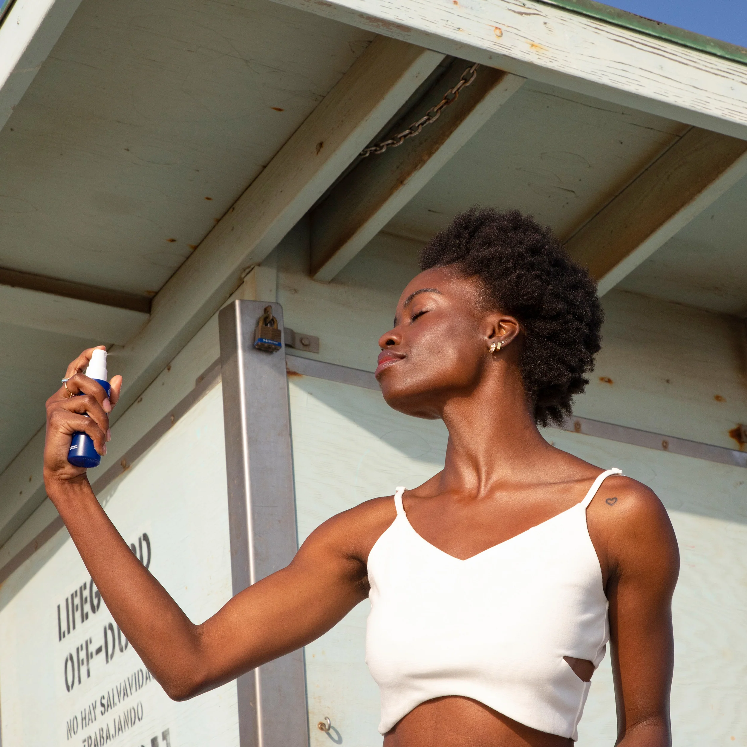 an image of a model spraying the refreshing water mist onto their face.