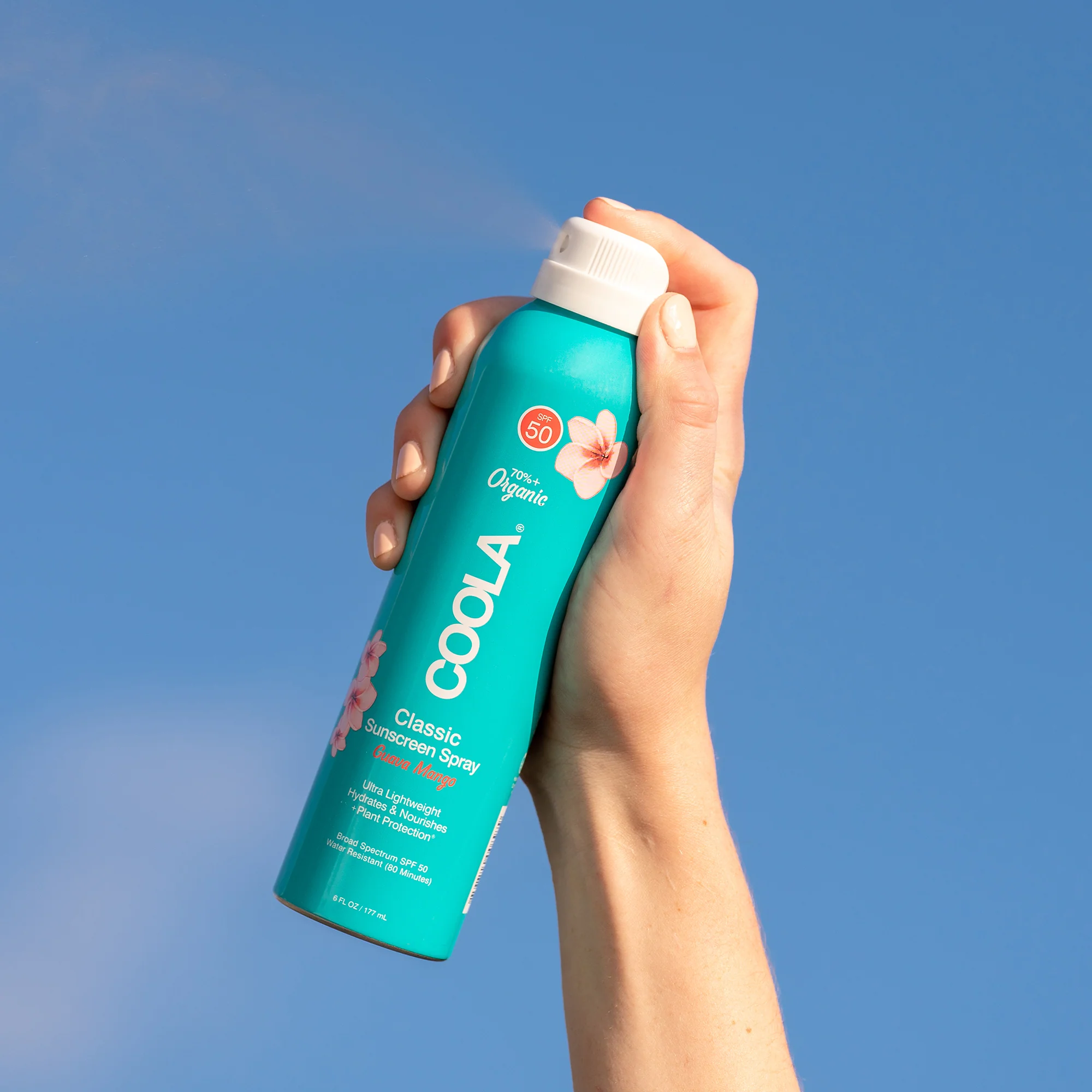 an image of the coola guava mango sun screen on a blue background.